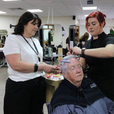 Michelle Jones (left) supervising a student styling a customer’s hair in the salon at Coleg Llandrillo’s Rhos-on-Sea campus
